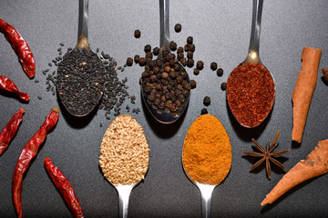 Top viewl group of spices, sesame, pepper, turmeric, cayenne pepper on spoon