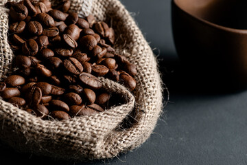 An open jute bag displaying a good amount of coffee beans.