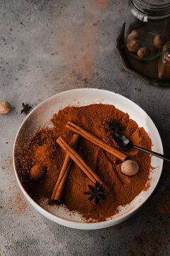 cinnamon falling in a bowl of spices used for baking
