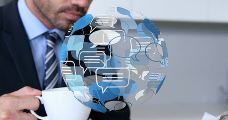 Image of globe with speech bubble over caucasian businessman using laptop