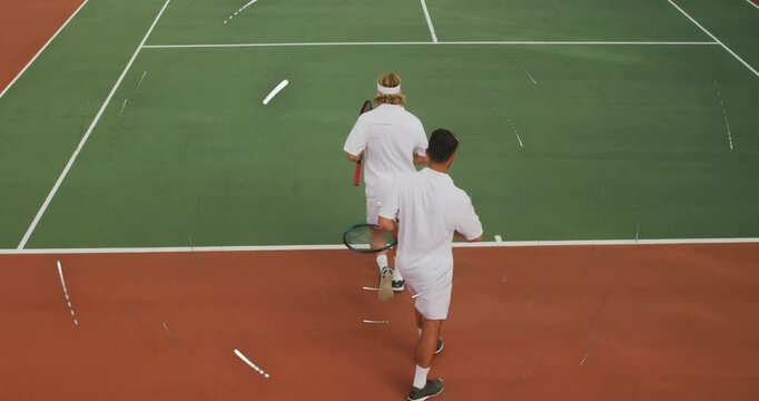 male tennis partners walking on outdoor court, with animated sports technology charts floating