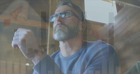 Image of financial data processing and statistics over caucasian man using laptop