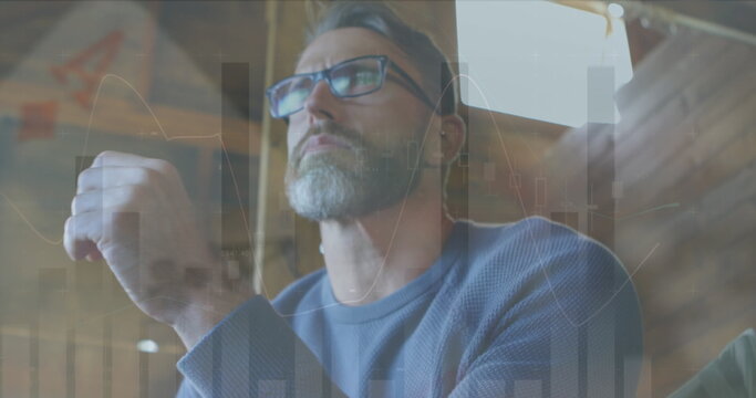 Image of financial data processing and statistics over caucasian man using laptop