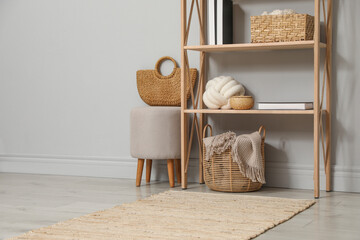 Wooden shelving unit with different home decor near light grey wall indoors. Space for text