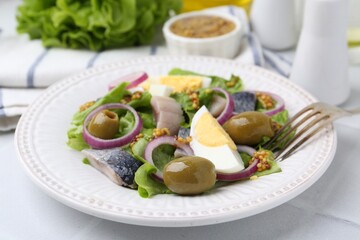 Delicious salad with herring, egg, mustard and vegetables on white tiled table, closeup