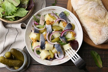 Delicious salad with herring and vegetables served on wooden table, flat lay