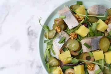 Delicious salad with herring on white marble table, top view. Space for text