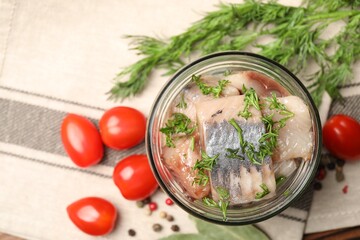 Pieces of delicious herring with dill in jar and tomatoes on table, flat lay