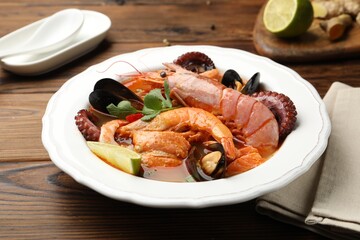 Delicious seafood soup served on wooden table, closeup