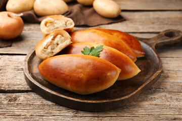 Tasty baked patties with potato and parsley on wooden table, closeup