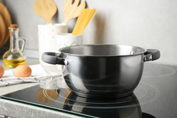 Cooking pot on cooktop indoors. Kitchen utensil