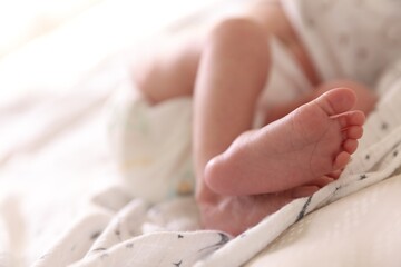 Little baby lying on bed indoors, closeup. Space for text