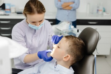 Obraz premium Female dentist examining teeth of child patient in dental clinic