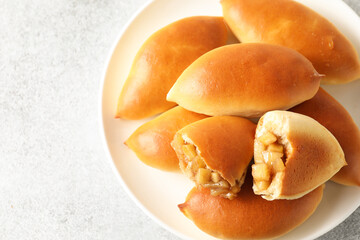 Tasty baked patties with apples on light grey table, top view