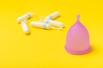 Menstrual cup on a bright background. Sanitary napkins, tampons and menstrual cup.Concept of critical days, menstruation.feminine hygiene product. Women health concept.Premenstrual syndrome.Copy space