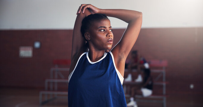 Black woman, basketball or stretching with arms for game, match or sport competition on court. Female person, African player or athlete getting ready with warm up or preparation for serious challenge