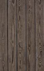 Dark wooden planks lay in a straight formation, showcasing rich grain patterns and textures. The rustic elegance makes it ideal for interior design, flooring, or various creative projects.