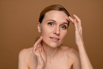 Aged beauty concept. Portrait of beautiful middle age woman touching silky skin on her face,...