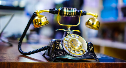 Vintage Rotary Phone Displayed with Elegant Golden Accents on Wooden Table selective focus image