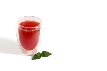 There is a transparent glass with watermelon juice on a white background.	