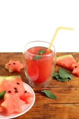 There is freshly squeezed watermelon juice on the wooden table.