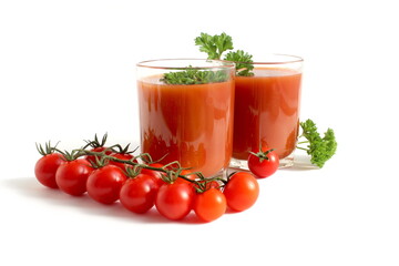 Two glasses with tomato juice stand on a white background.