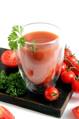 There is tomato juice in a glass on a white background.	