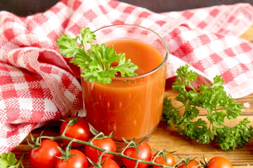 Tomato juice is on the table with tomatoes.