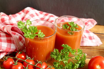 Two glasses of tomato juice are on the table.	