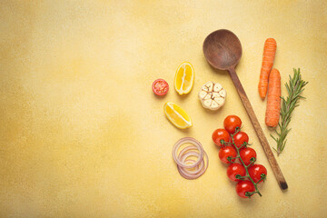 Cherry tomatoes, garlic, lemon slices, carrots, red onions, and rosemary sprig arranged alongside a...