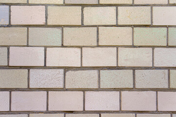 A brick wall with a white brick. The bricks are stacked on top of each other.