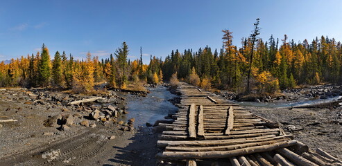 Russia. The Altai Mountains. A dilapidated wooden bridge over the Aktra River, which all-terrain...