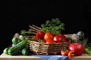 Fresh vegetables basket presenting vibrant tomatoes, cucumbers, garlic, and dill on rustic wooden table