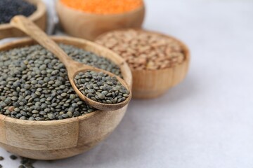 Different types of lentils on light table, closeup