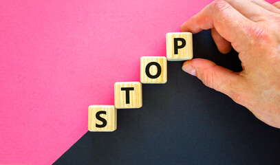 Stop symbol. Concept word Stop on beautiful wooden blocks. Businessman hand. Beautiful black and...
