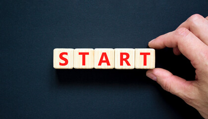 Start symbol. Concept word Start on beautiful wooden blocks. Beautiful black table black...
