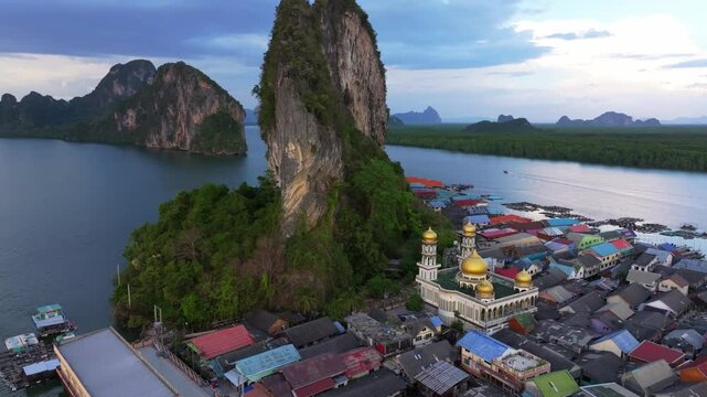 Koh Panyi's floating homes rise above Phang Nga Bay waters, Thailand. Aerial drone video