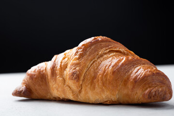 Delicious french croissant on the table, black background