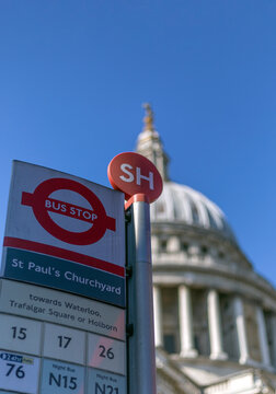 LONDON, UK - APRIL 01, 2025:  London Transport bus stop with sign for St Paul's Churchyard and defocussed dome of St Paul's Cathedral in the background