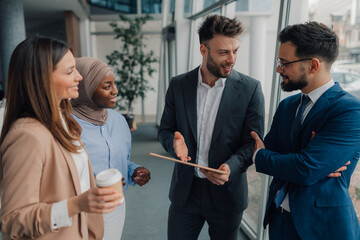 Business people discussing work in office hallway