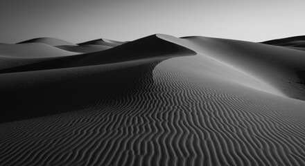 Black and white sand dunes with rippled texture under dramatic sky. Desert landscape. Natural pattern formation. Environmental conservation. Wilderness exploration. Minimalist nature composition