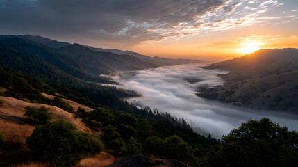 Fototapeta premium Hazy mountain view with golden sunset over a fog-filled valley.