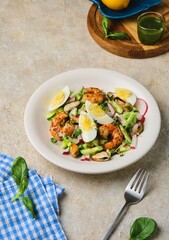 Salad of fresh cucumber, radish and eggs with seafood in a ceramic plate on a light concrete background. Salad recipes.