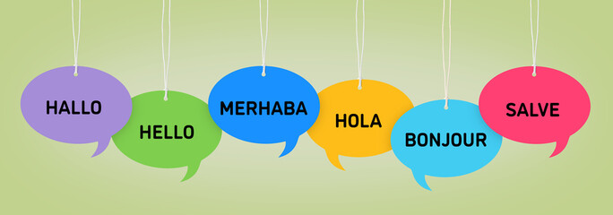 Paper speech bubbles with greetings in different languages hanging on sage color background. Banner design © New Africa