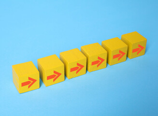Guide. Yellow cubes with arrows pointing in one direction on light blue background