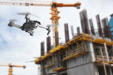 Drone with camera flying near unfinished building. Unmanned aerial vehicle for surveillance