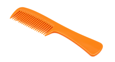 Close up view of a single orange plastic comb with handle on a black background in studio lighting