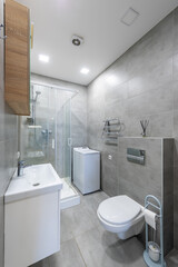 Modern Bathroom with Shower, Washing Machine, and Gray Tile Walls