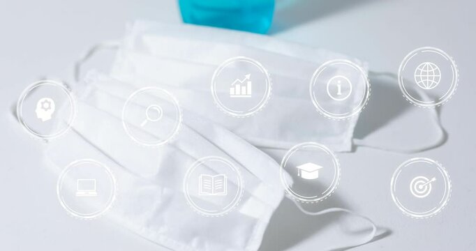 Two white masks floating on white surface, featuring nine semi transparent education and tech icons