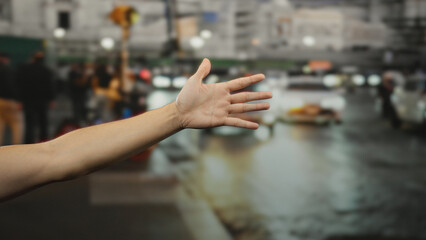 Man extends hand on busy city street, with blurred background of urban life at night, suggesting an...